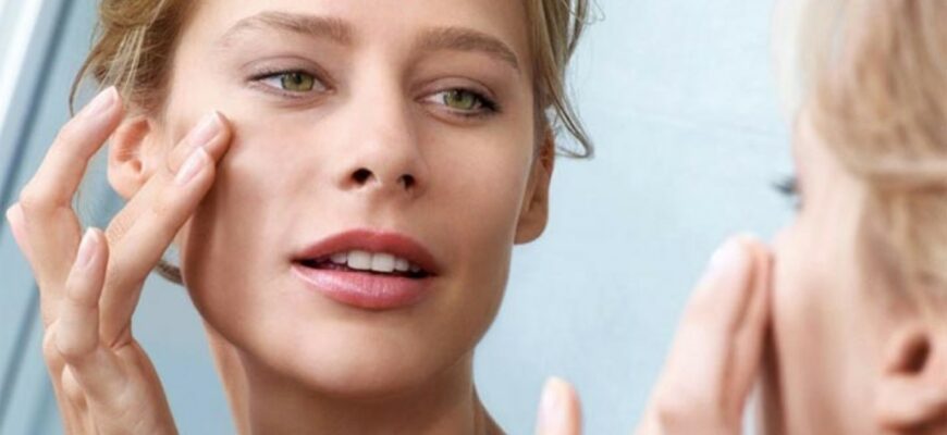 женщина трогает свое лицо рукой